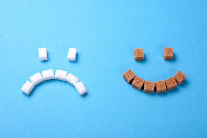 white sugar cubes making a happy face and brown cubes making a sad face