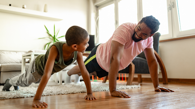 A father and son practice body weight exercises at home.