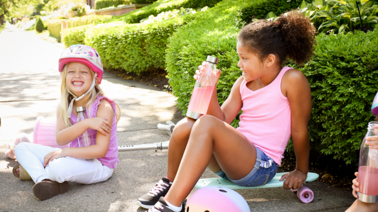 Kids sharing True Lemon Kids together outside while riding bikes. 