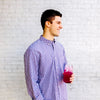 A young man smiles and holds a glass of True Lemon Wildberry Lemonade. 