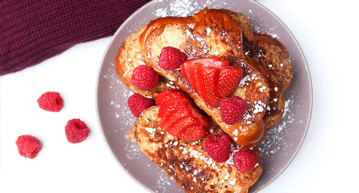 Plated french toast topped with strawberries