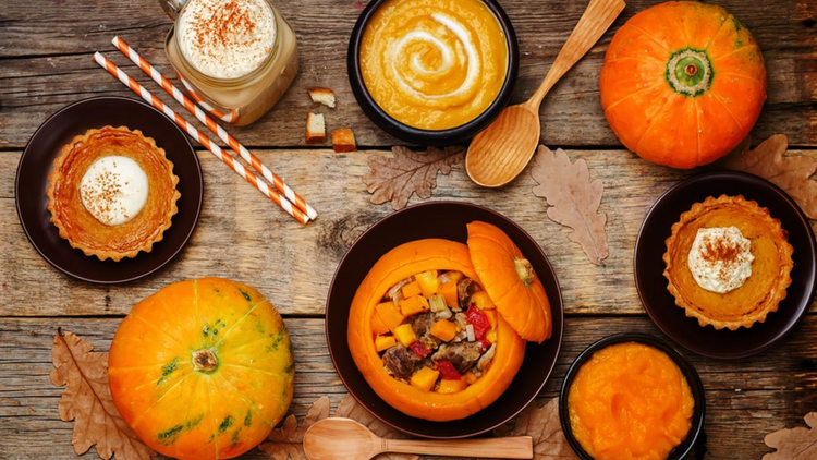 A table spread of different squash recipes for Autumn, like pumpkin pie and butternut squash soup.