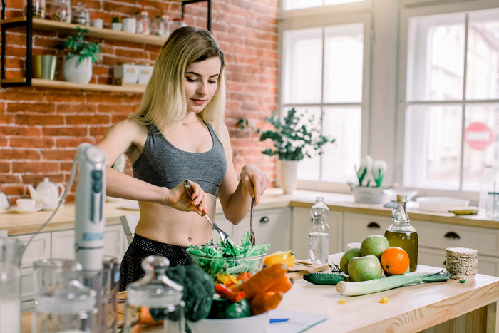 young-woman-preparing-healthy-food-cooking-vegetables-in-kitchen-at-home-clean-eating-spring-diet