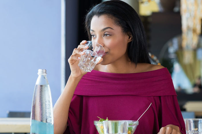 women drinking water while enjoying a salad