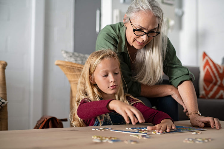 things-to-do-social-distancing-coronavirus-positive-older-woman-with-grandchild-doing-puzzle-at-home-covid19-coronavirus