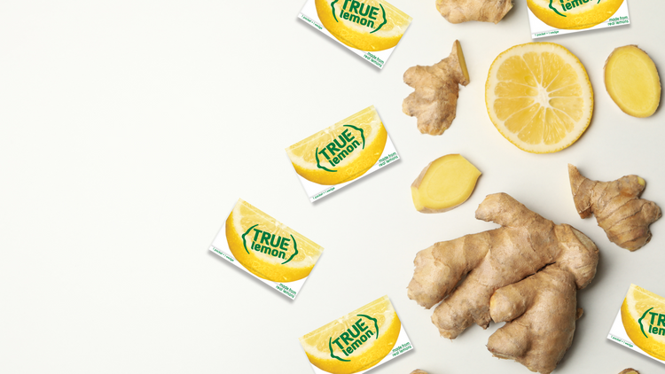 Ginger, lemon, and True Lemon packets spread along a white backdrop.