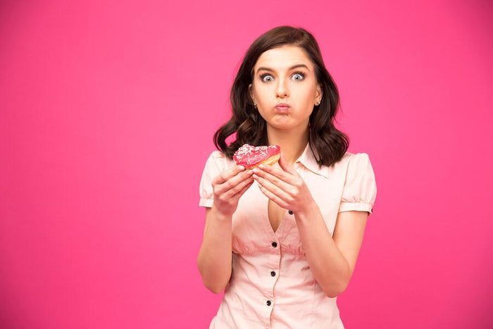 women in all pink eats pink donut