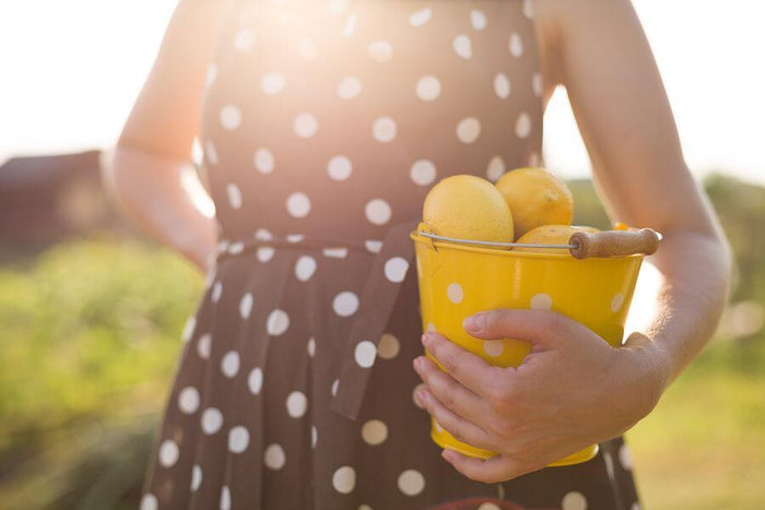 women holds bucket of lemons