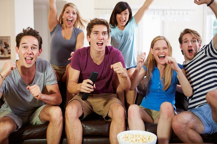 group of friends cheers towards a television