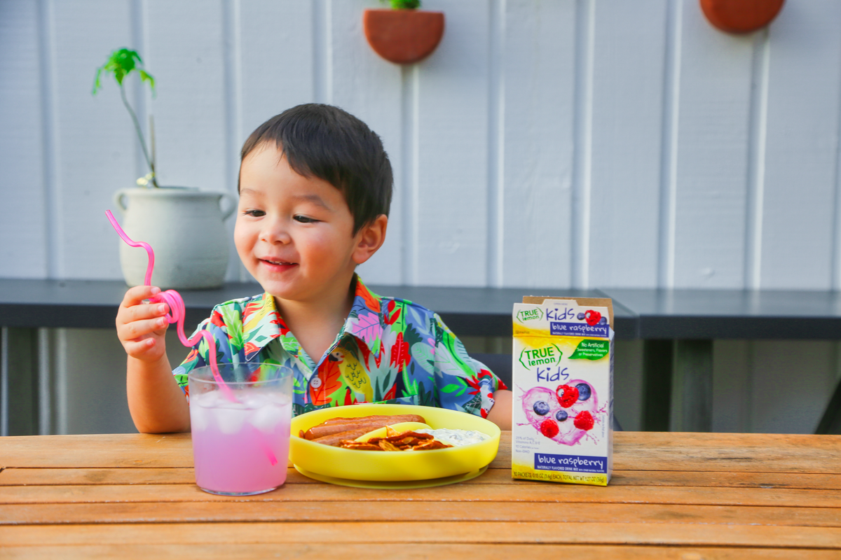 A little boy holding drink straw