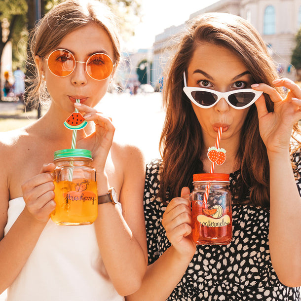 Two young women wearing stylish sunglasses sip True Lemon Lemonade out of mason jars.
