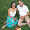 A smiling couple lounges outside in the grass and drinks glasses of True Lemon Iced Tea.