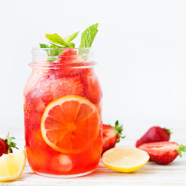 A mason jar filled with strawberry lemonade and fresh chopped strawberries. 